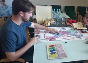 Pokaż zdjęcie: Mateusz Krzyszkowski testujący grę planszową w siedzibie Oddziału Małopolskiego