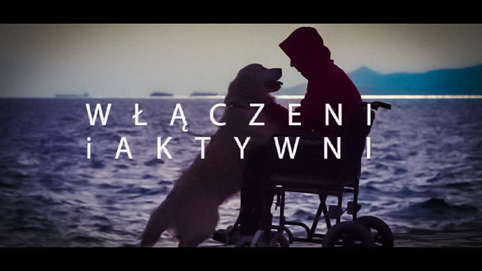 Pokaż zdjęcie: Osoba na wózku z psem na kolanach, napis "Włączeni i aktywni"