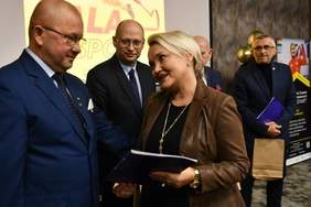 Pokaż zdjęcie: Dyrektor Oddziału Lubuskiego PFRON z uśmiechem na twarzy składa gratulacje, ubranemu w garnitur, Prezesowi Start Gorzów