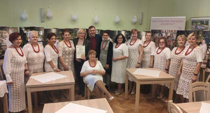 Pokaż zdjęcie: Koronczarki z Klubu SZYDEŁKO oraz dyrektor Marta Mordarska i prezes Adam Stromidło. Wszystkie koronczarki ubrane są w ręcznie robione koronkowe białe suknie