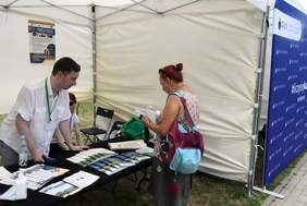 Pokaż zdjęcie: Zainteresowana pomocą finansową przed stoiskiem PFRON 