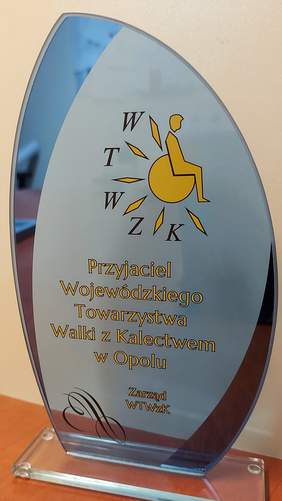 Pokaż zdjęcie: Szklana statuetka w kształcie żagla. na tafli szkła napis: PRZYJACIEL WOJEWÓDZKIEGO TOWARZYSTWA WALKI Z KALECTWEM W OPOLU
