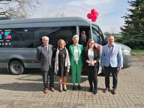 Zaproszeni goście stoją na tle nowego autobusu