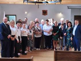 Pokaż zdjęcie: Liczna grupa osób - kobiety i mężczyźni pozują do zdjęcia.