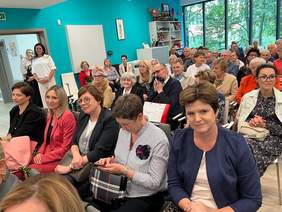 Pokaż zdjęcie: Goście w większości kobiety siedzą na krzesełkach.