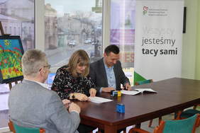 Pokaż zdjęcie: Przedstawiciele Fundacji Heros w tle baner z logo PFRON