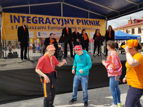 występ kilku osób na scenie, pod sceną kilka osób tańczy