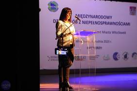 Prelegentka pzremawia na scenei