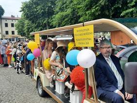 Pokaż zdjęcie: Tłum ludzi, który kroczy ulicami Wieruszowa. Wszyscy są ubrani na kolorowo i tworzą różnobarwny pochód. Jest też meleks, którym jadą dzieci i dorośli. 