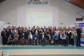 Pokaż zdjęcie: W dużej hali na tle prezentacji "Start" Zielona Góra stoją zawodnicy "Start", trenerzy, działacze, Dyrektor Oddziału Andrzej Gonia