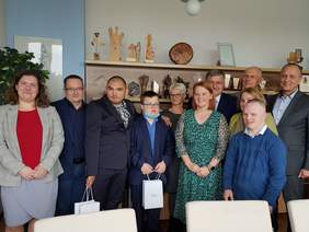 Grupa ok 10 osób, mężczyzn i kobiet pozują do zdjęcia, są w gabinecie dyrektora PFRON