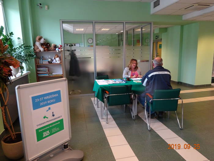 Pokaż zdjęcie: Na zdjęciu pracownik Oddziału Mazowieckiego PFRON  wraz z osobą zainteresowaną pozyskaniem informacji.  Siedzą przy stoliku, na którym leżą materiały informacyjne.