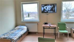 Pokaż zdjęcie: Przykładowy pokój, wyposażony w łóżka, krzesła, stolik, telewizor zaieszony na ścianie, bardzo przestronny, utrzymany w jasnej, pastelowej kolorsytyce