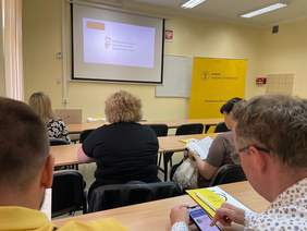 Pokaż zdjęcie: Widoczny ekran z prezentacją PFRON dla uczestników spotkania