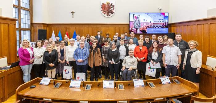 Uczestnicy Sesji stoją w półkolu, pozując do zdjecia