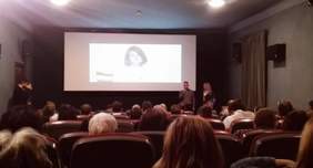 Pokaż zdjęcie: Pełna sala w Kinie pod Baranami. Na ekranie filmik z dr Anną Jankowską