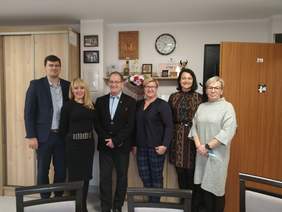 Pokaż zdjęcie: Cztery panie oraz dwóch panów ustawionych na tle meblościanki.