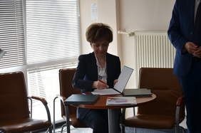 Pokaż zdjęcie: Osoba składa podpis pod umową