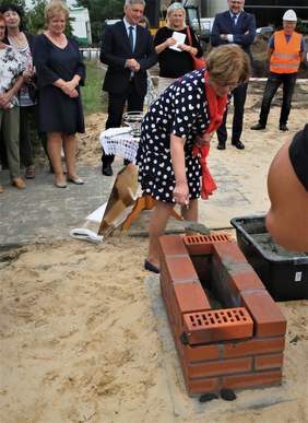 Dyrektor Kuj.-Pom. Oddziału PFRON - Aleksandra Gierej - wmurowuje kamień węgielny i dokumenty