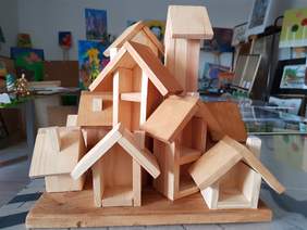 Pokaż zdjęcie: Rzeźba z drewna przedstawiająca dom złożony z małych domków