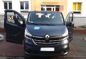 Pokaż zdjęcie: na zdjęciu: przód samochodu. Po bokach otwarte drzwi auta.