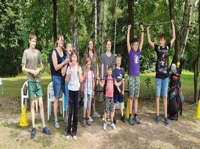 Pokaż zdjęcie: Dzieci bawią się w parku w rękach trzymają kije do golfa i pozują do zdjęcia