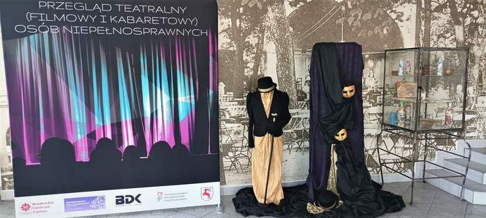 Roll up promujący IV Przegląd Teatralny...,a obok dekoracja nawiazująca doteatru - elegancki strój i maski 