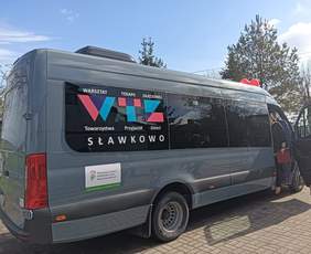 Nowy autobus, na szybie tylnej ma nazwę warsztatu, a pod spodem naklejkę z logo i pełną nazwą PFRON