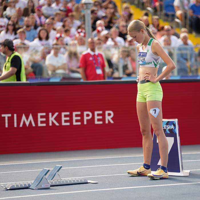 Zawodniczka na bieżni w blokach startowych przygotowuje się do biegu na 200 m.