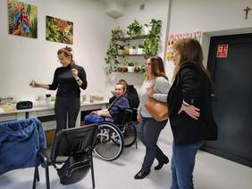 Pokaż zdjęcie: Terapeuta zajęciowy prezentuje pracownię Pani Dyrektor PFRON.