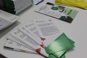 Ulotki informacyjne dla osób z niepełnosprawnościami rozłożone na stole podczas wydarzenia informacyjnego PFRON.