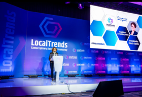 Prelegentka przemawia na scenie podczas konferencji LocalTrends – Samorządowy Kongres Finansowy. Stoi przy mównicy, za nią duży ekran z logo wydarzenia i prezentacją dotyczącą Sopotu.