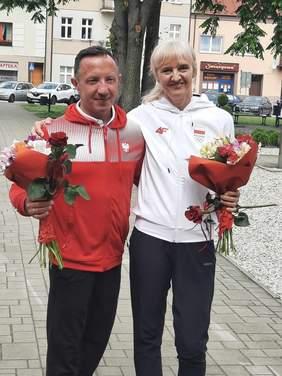 Pokaż zdjęcie: Stoją polscy sportowcy: Urszula Kielan i Tomasz Hamerlak. Trzymają w rękach kolorowe kwiaty. 
