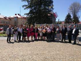 Zdjęcie grupowe na rynku kilkunastu osób