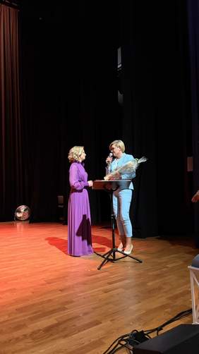 Pokaż zdjęcie: Moment wręczenia kwiatów i podziękowań na scenie podczas uroczystości jubileuszowej ŚDS w Bielsku Podlaskim.