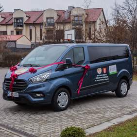 Pokaż zdjęcie: 9-osobowy mikrobus Ford Transit Custom MCA - samochód dofinansowany ze środków PFRON dla uczniów SOSW w Skawinie (Fot. SOSW w Skawinie) Na zdjęciu samochód symbolicznie przewiązany czerwoną wstęgą