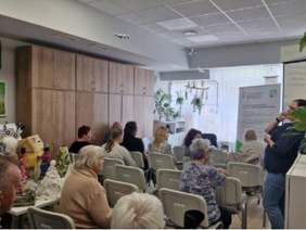 Pokaż zdjęcie: grupa osób zadających pytania przedstawicielce PFRON