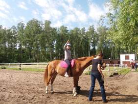 Pokaż zdjęcie: Dziecko jadące na koniu machające ręką