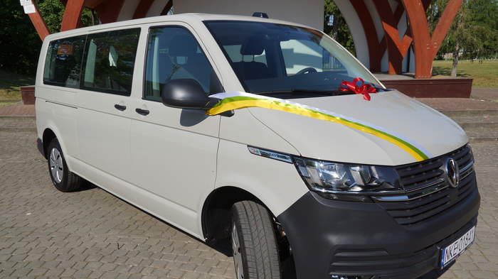 Pokaż zdjęcie: Biały bus z kolorową szarfą