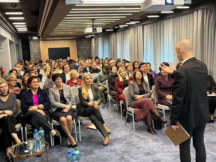 Pokaż zdjęcie: Sala konferencyjna zdjęcie uczestników siedzących na krzesłach.
