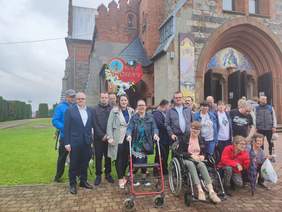 Pokaż zdjęcie: Na zdjęciu grupa z WTZ w Osinach, pozujących do zdjęcia przed kościołem, w którym odbyła się Msza Święta w intencji uczestników spotkania