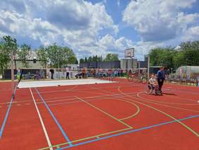 Pokaż zdjęcie: Nowoczesne boisko z rozrysowanym polem gry dla różnych dyscyplin sportowych. Boisko w kolorze czerwonym.