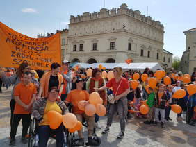 Tłumy ludzi z pomarańczowymi balonami i elementami ubrań w tym kolorze zebrani na jarosławskim rynku