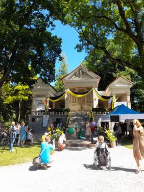 Pokaż zdjęcie: Na scenie trwa występ grupy teatralnej, aktorzy maja w rękach duże kolorowe piłki.