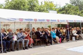 Pokaż zdjęcie: Pod namiotem, na krzesełkach siedzą zaproszeni goście.