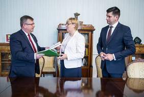 Pokaż zdjęcie: Marszałek Witold Kozłowski, Dyrektor Marta Mordarska oraz Wicemarszałek Łukasz Smółka podczas przekazywania umowy podpisanej w ramach Programu "Stabilne Zatrudnienie"