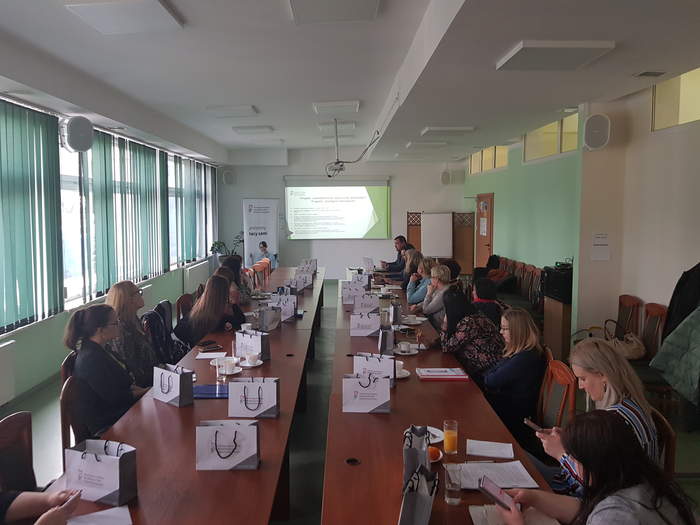 Pokaż zdjęcie: Sala, gdzie przy dużym stole siedzą po obu stronach pracownicy PCPR w Lubuskiem, na środku na końcu sali jest wyświetlona prezentacja PFRON