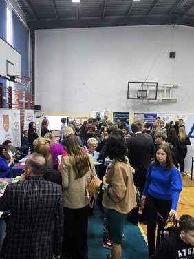 Pokaż zdjęcie: Tłum osób wokół stoisk, podczas targów pracy.