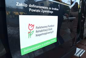 Pokaż zdjęcie: na zdjęciu plansze naklejone na samochód z napisem: Zakup dofinansowano ze środków powiatu zgierskiego oraz Dofinansowane ze środków PFRON
