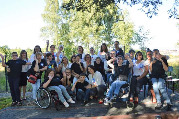 Pokaż zdjęcie: Uczestnicy uroczystości jubileuszowych. Grupa uśmiechniętych osób pozuje do zdjęcia